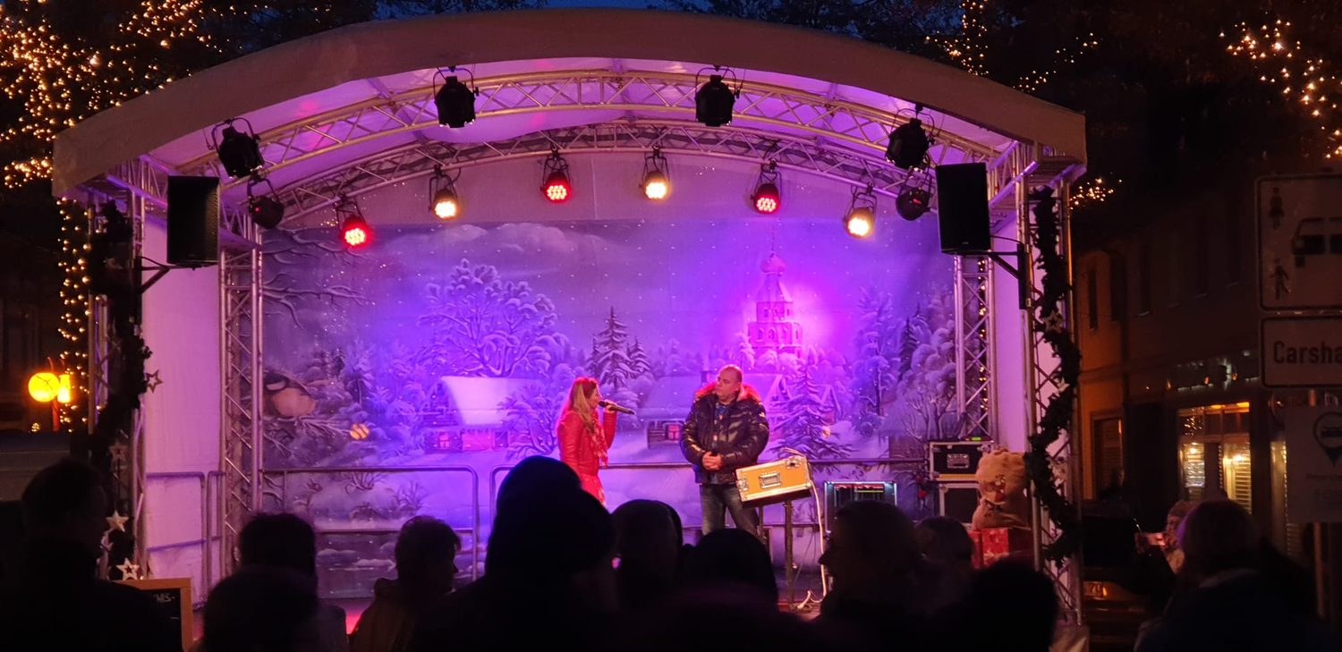 Weihnachtsmarkt mit Bühne, Publikum und Beleuchtung